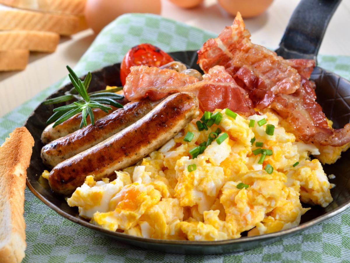 A Breakfast Plate With Eggs Toast And Fruit On The Table Next To A