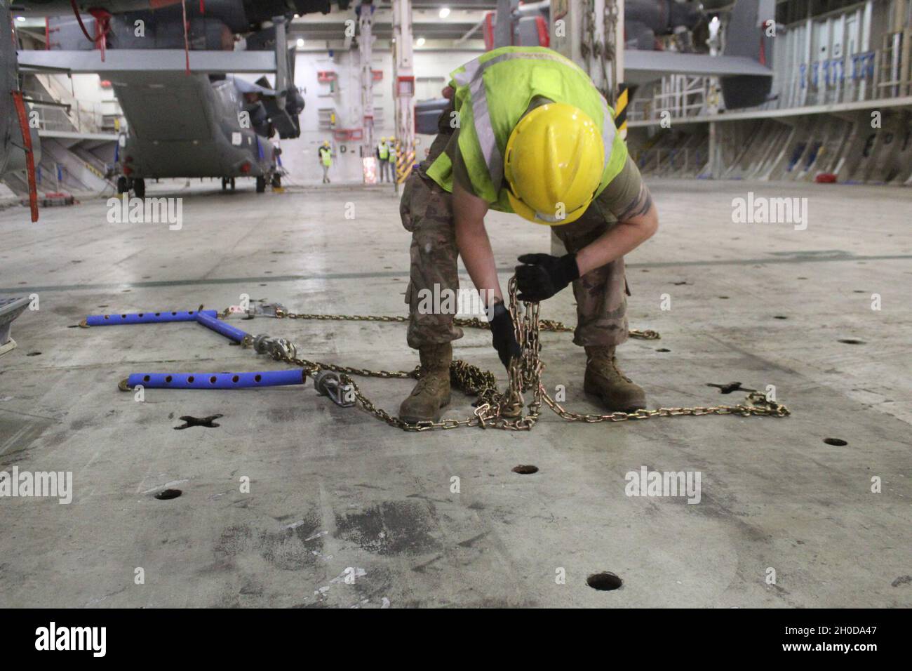 An Air Force Mechanic Prepares Tie Down Chains For Use In Securing An