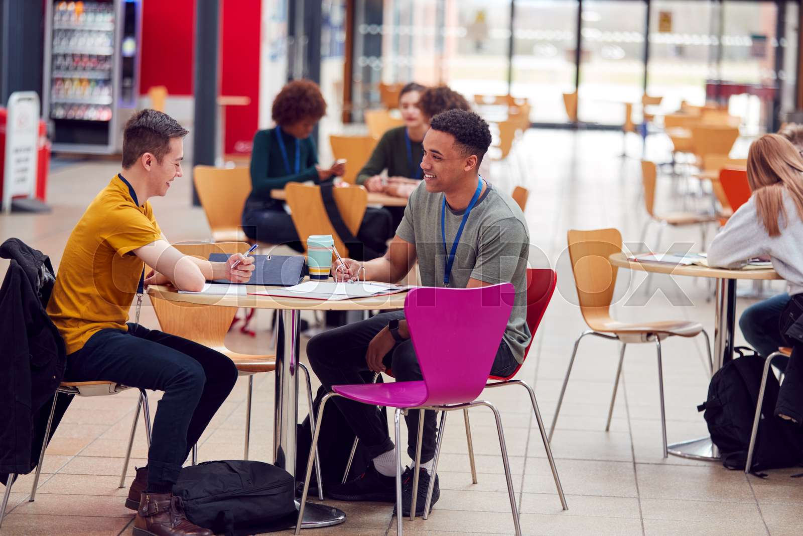 Communal Area Of Busy College Campus With Students Working At Tables