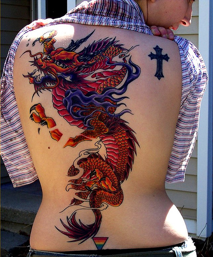 The Back Of A Man S Body With A Dragon Tattoo On His Upper Half